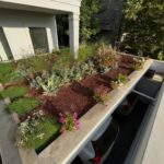 עיצוב גינה קטנה ומודרנית עם דק סינטטי ועציצים דקורטיביים